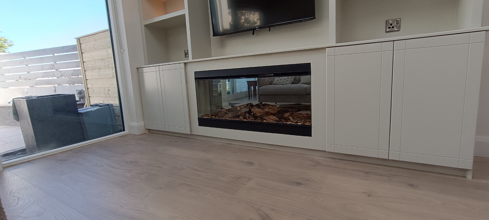 Built-in fireplace and storage cabinets with engineered wood floor